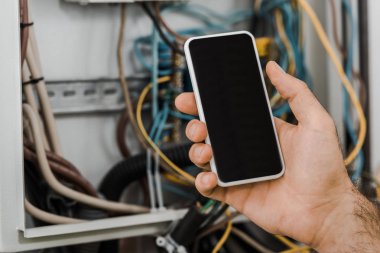 elektrikçi elektrik kutusu koridorda yakınındaki boş ekran ile akıllı telefon tutarak resim kırpılmış