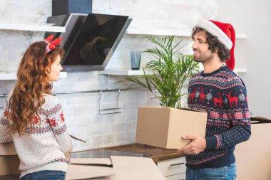 karton açma mutlu genç çift yeni evinde Noel kutuları. 