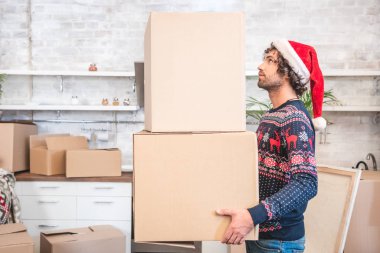 Noel Baba şapkası karton kutular tehcir sırasında tutan genç adam yan görünüm