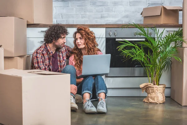 Boyfriend Girlfriend Sitting Laptop Cardboard Boxes Floor New Kitchen Looking — Stock Photo, Image