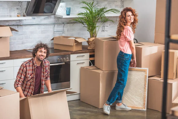 Sorrindo Casal Desembalando Caixas Papelão Nova Casa Olhando Para Câmera — Fotografia de Stock