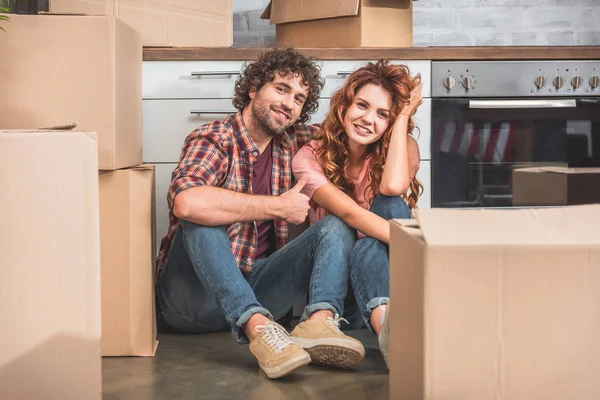 Smiling Couple Sitting Floor Cardboard Boxes New Kitchen Boyfriend Showing — Stock Photo, Image