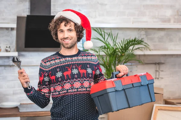 Szczęśliwy Młody Człowiek Santa Hat Gospodarstwa Przybornika Uśmiecha Się Kamery — Zdjęcie stockowe