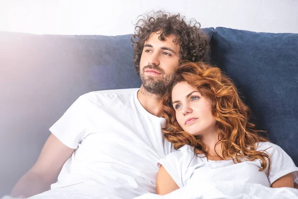 Jovem Casal Pensativo Olhando Para Longe Enquanto Deitado Juntos Cama — Fotografia de Stock