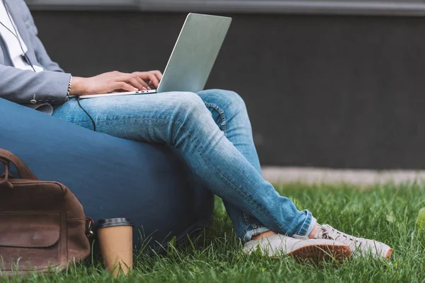 坐在豆袋椅上的 Teleworker 使用笔记本电脑裁剪视图 — 图库照片