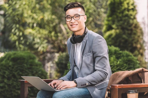 Lächelnder Asiatischer Freiberufler Der Auf Der Bank Laptop Arbeitet — Stockfoto