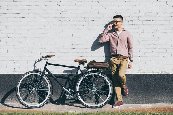 Asiático Hombre Elegante Ropa Hablando Smartphone Mientras Pie Cerca Bicicleta — Foto de stock gratis