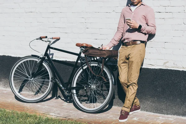 Partial View Man Stylish Clothing Using Smartphone While Standing Bicycle — Free Stock Photo