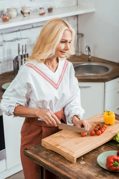 Atractiva Mujer Adulta Preparando Ensalada Para Cena Cortar Tomates Cherry — Foto de stock gratis