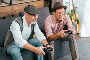 yakışıklı olgun erkek evde gamepad ile oynarken yüksek açılı görünüş