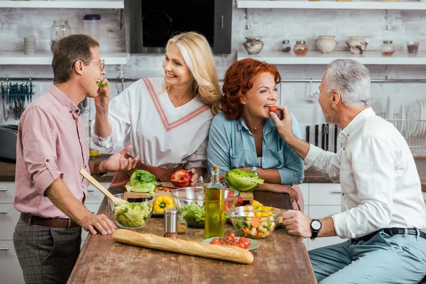 Parejas Maduras Felices Alimentándose Mutuamente Durante Preparación Ensalada Para Cena — Foto de Stock