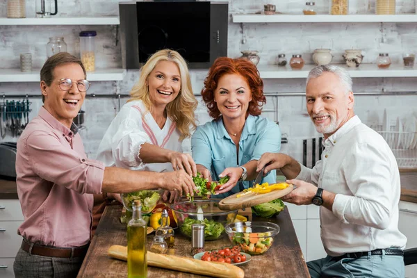 Glade Gamle Venner Forbereder Salat Til Middag Sammen Hjemme - Stock-foto