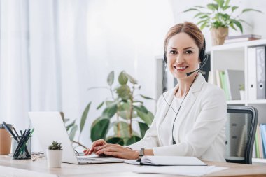 support operator working with headset and laptop in call center clipart