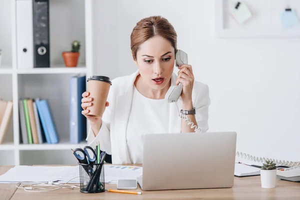 Bela Empresária Chocada Segurando Café Para Enquanto Conversa Telefone Trabalhando — Fotografia de Stock
