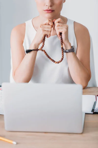 Vista Recortada Mujer Negocios Rezando Con Cuentas Rosario Mirando Ordenador — Foto de Stock