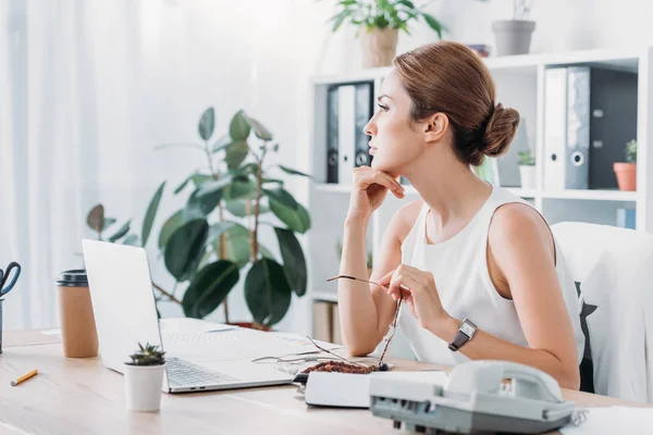 Nachdenkliche Geschäftsfrau Sitzt Mit Laptop Arbeitsplatz Modernen Büro — kostenloses Stockfoto