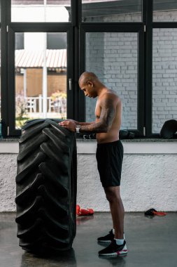 Lastik içinde jimnastik salonu ile eğitim kas gömleksiz adam yan görünüm 