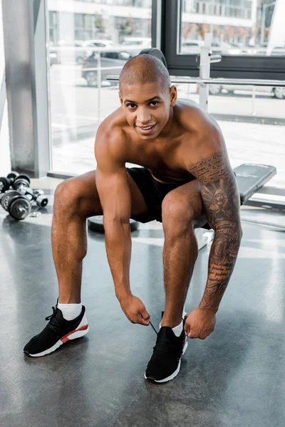 Young Muscular African American Sportsman Tying Shoelaces Smiling Camera Gym — Free Stock Photo