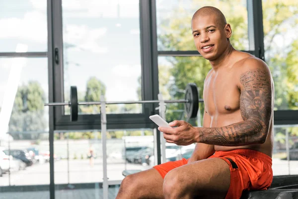 Sonriente Deportista Afroamericano Con Mano Tatuada Sosteniendo Teléfono Inteligente Mirando — Foto de Stock