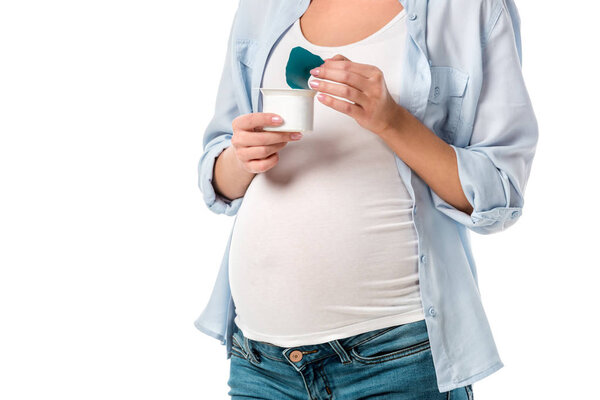 cropped shot of pregnant woman holding yogurt isolated on white