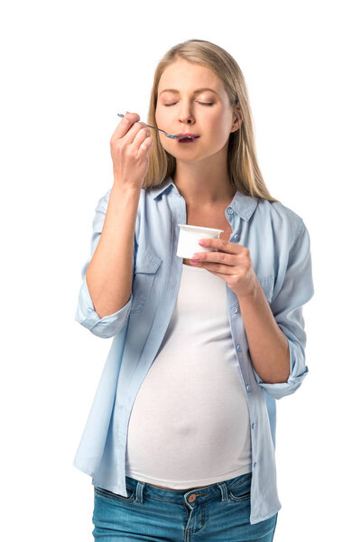 happy pregnant woman with closed eyes eating yogurt isolated on white