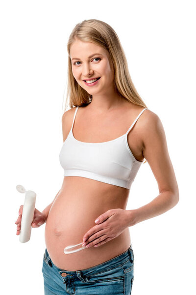 pregnant woman applying lotion on her belly to avoid stretch marks isolated on white