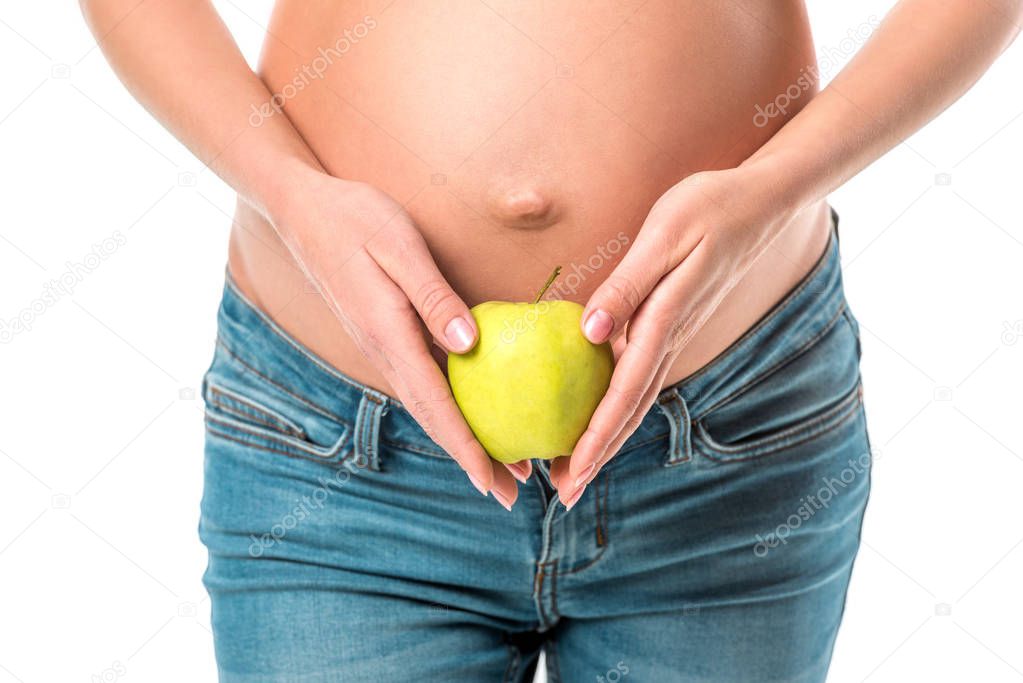 cropped view of pregnant woman holding fresh healthy apple near her belly isolated on white