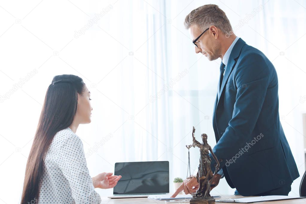 lawyer and young female client using laptop in office