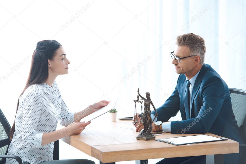 side view of lawyer and client discussing papers in office