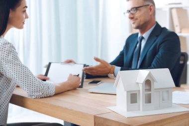 gözlük ve kadın müşteri toplantısı kağıt ev model ofis, ev sigorta kavramı ile işyerinde sigorta acentesi