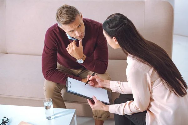 Female Psychologist Pointing Blank Clipboard Therapy Appointment Male Patient — Stock Photo, Image