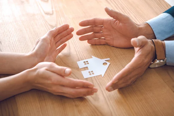 保险代理人与女性手的部分视角在木制桌面上的纸房模型 房屋保险概念 — 图库照片