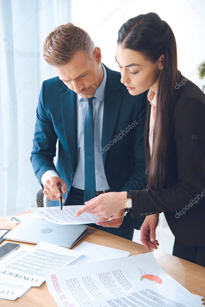 focused business colleagues doing paperwork at workplace in office