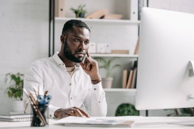 bilgisayarda Office çalışan ciddi yakışıklı Afrikalı-Amerikalı iş adamı