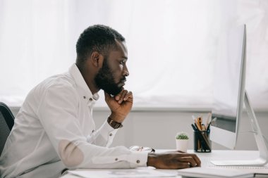 bilgisayarda Office çalışan yakışıklı Afrikalı-Amerikalı işadamı yan görünüm