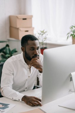 bilgisayarda Office çalışan dalgın yakışıklı Afrikalı-Amerikalı iş adamı