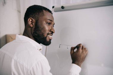 flipchart Office çizim ve uzak seyir yakışıklı Afrikalı-Amerikalı işadamı gülümseyen