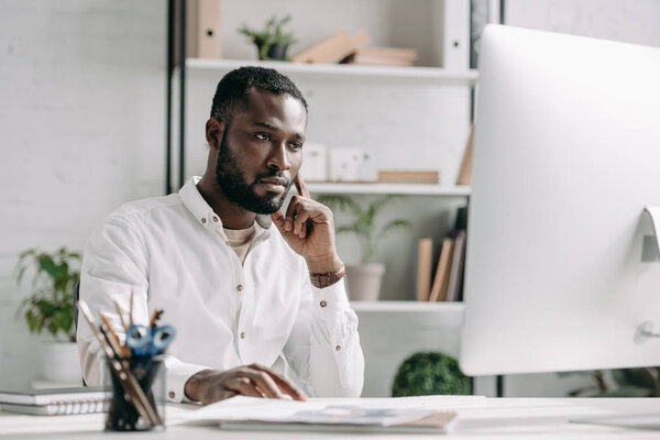 serious handsome african american businessman working at computer in office