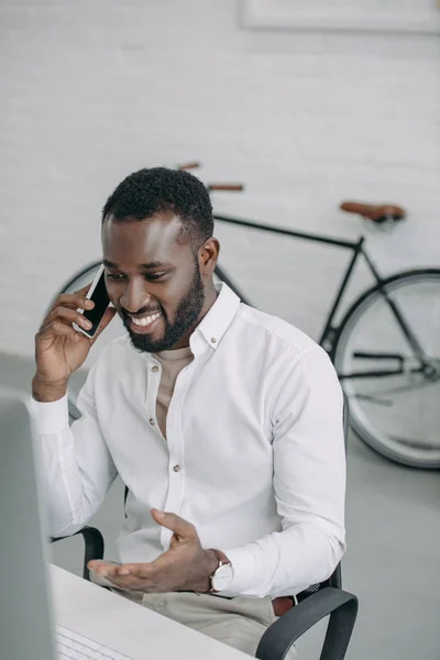 Sorrindo Bonito Empresário Afro Americano Falando Por Smartphone Gesticulando Escritório — Fotografia de Stock