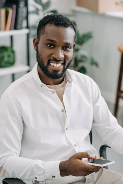 Sorrindo Bonito Empresário Afro Americano Segurando Smartphone Olhando Para Câmera — Fotografia de Stock