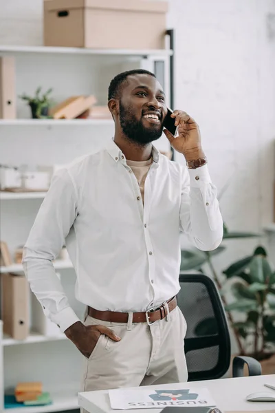 Sorrindo Bonito Empresário Afro Americano Falando Por Smartphone Escritório Olhando — Fotografia de Stock