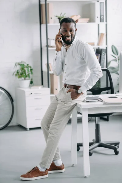 Apuesto Hombre Negocios Afroamericano Apoyado Mesa Hablando Por Teléfono Inteligente — Foto de stock gratis