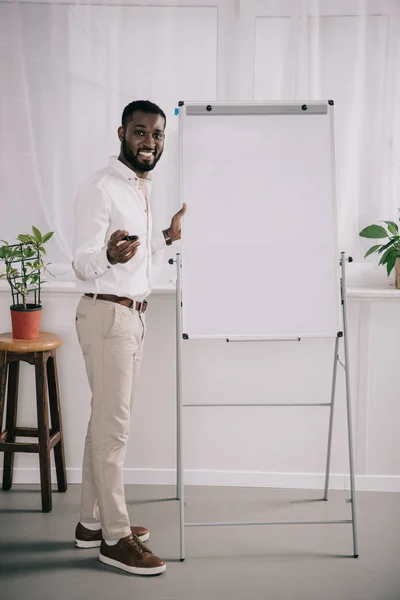 Smiling Handsome African American Businessman Standing Flipchart Gesturing Office — Stock Photo, Image