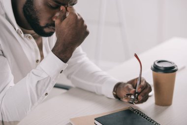 burun Köprüsü ve holding gözlük Office dokunmadan yorgun Afrikalı-Amerikalı iş adamı