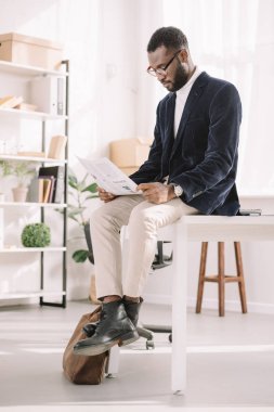 modern ofis gazete okuma kadife ceketli Afrikalı-Amerikalı iş adamı