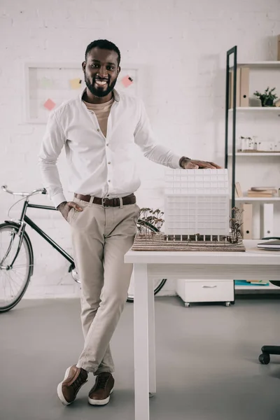 Sorridente Bonito Arquiteto Afro Americano Tocando Modelo Arquitetura Olhando Para — Fotografia de Stock Grátis