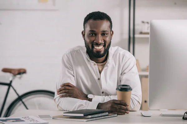 Sonriente Guapo Afroamericano Empresario Sosteniendo Taza Café Desechable Oficina Mirando — Foto de Stock