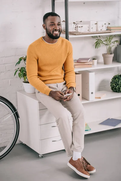 Guapo Diseñador Afroamericano Alegre Suéter Amarillo Usando Teléfono Inteligente Oficina — Foto de stock gratis