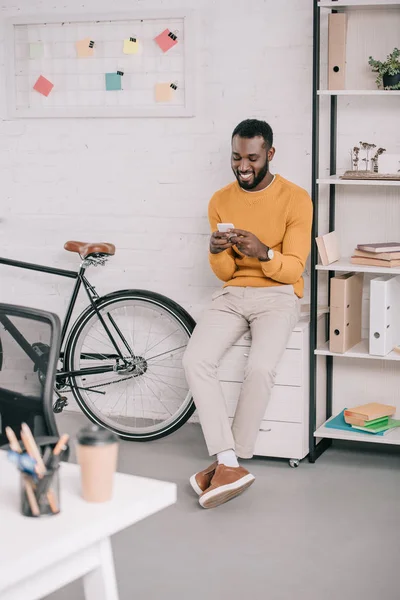 Souriant Designer Afro Américain Pull Jaune Utilisant Smartphone Dans Bureau — Photo