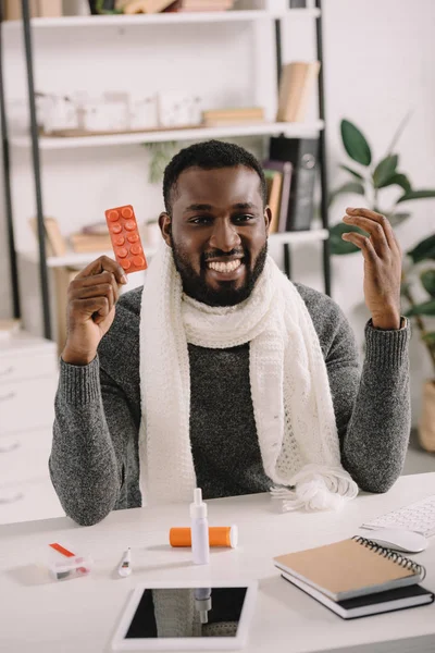 Alegre Enfermo Afroamericano Empresario Sosteniendo Pastillas Mientras Está Sentado Lugar — Foto de stock gratis